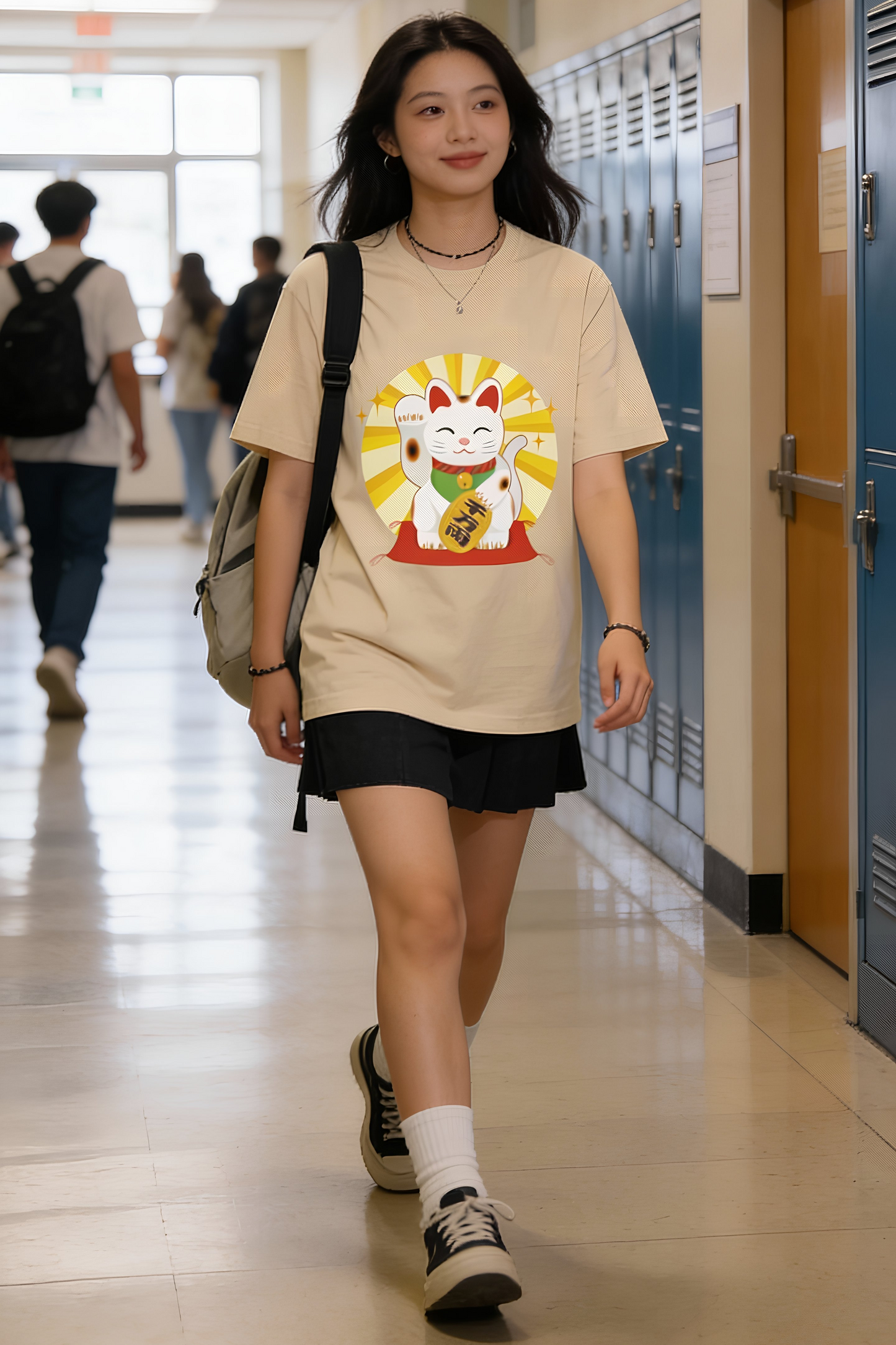 Beige Maneki Neko graphic t-shirt worn by woman walking in a school hallway