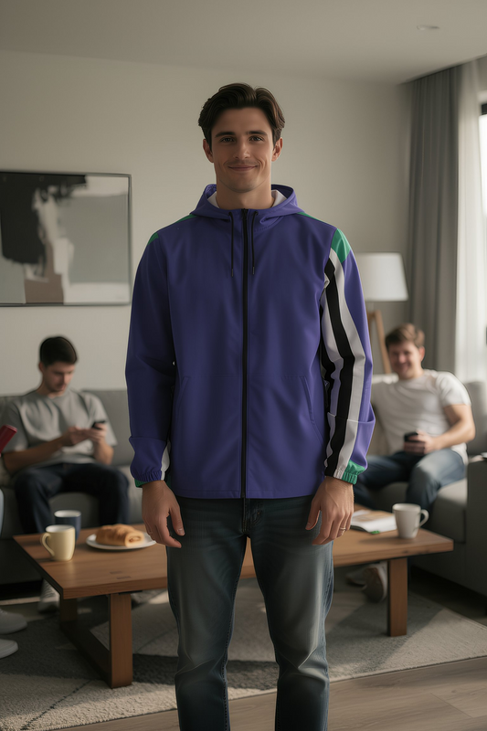 Man wearing retro color block windbreaker jacket in blue and green with striped sleeve detail indoors, casual outfit