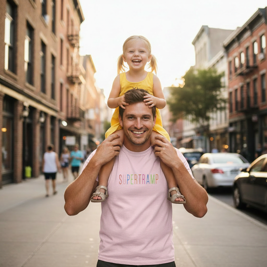 Man carrying a child on his shoulders in an urban setting, he is wearing a light pink 'Supertramp' band t-shirt