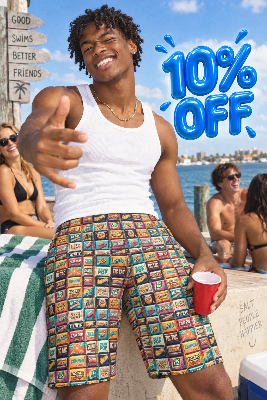 A smiling man at a beach or poolside wears colorful patterned swim shorts and a white tank top, pointing toward the camera while holding a red cup. Large blue text reads '10% OFF' over the scene.