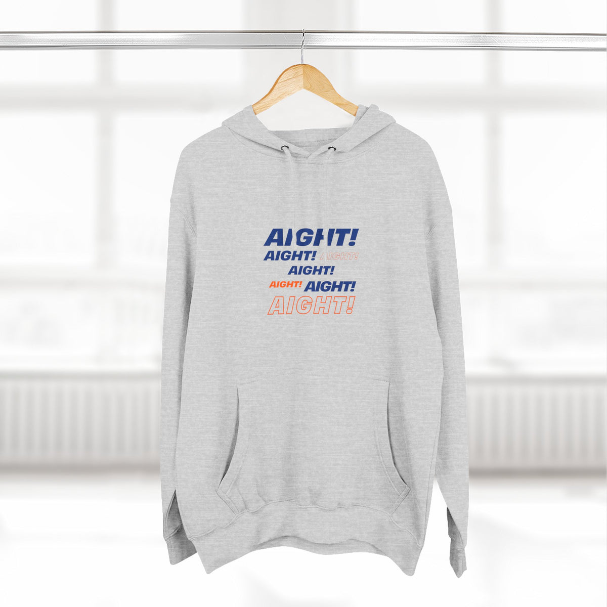Gray AIGHT hoodie with blue and orange text hanging on wooden hanger in bright room