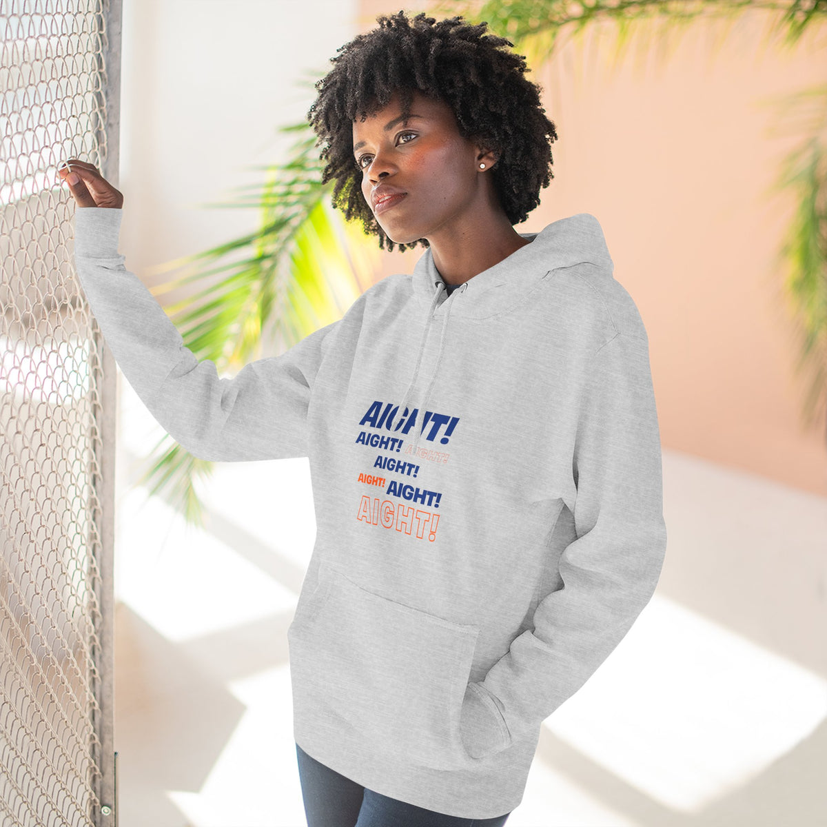 Woman wearing the gray Aight graphic hoodie in a bright casual lifestyle setting
