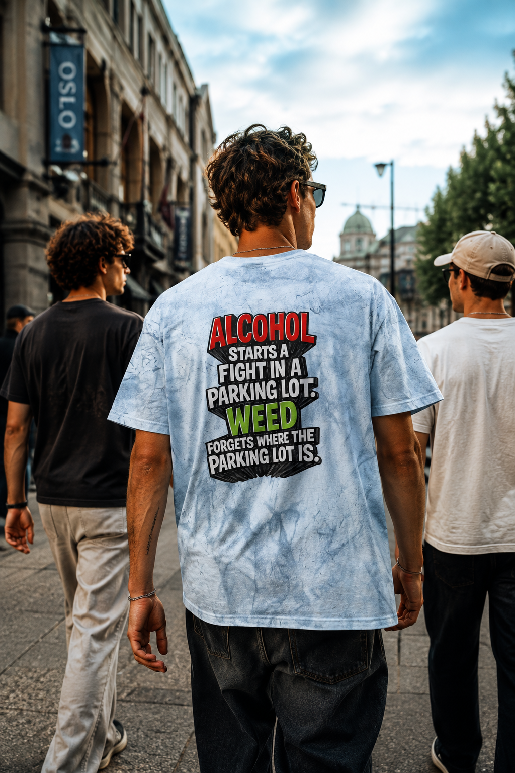 Male millennial wearing blue Alcohol vs Weed tie-dye T-shirt while walking with friends in Oslo