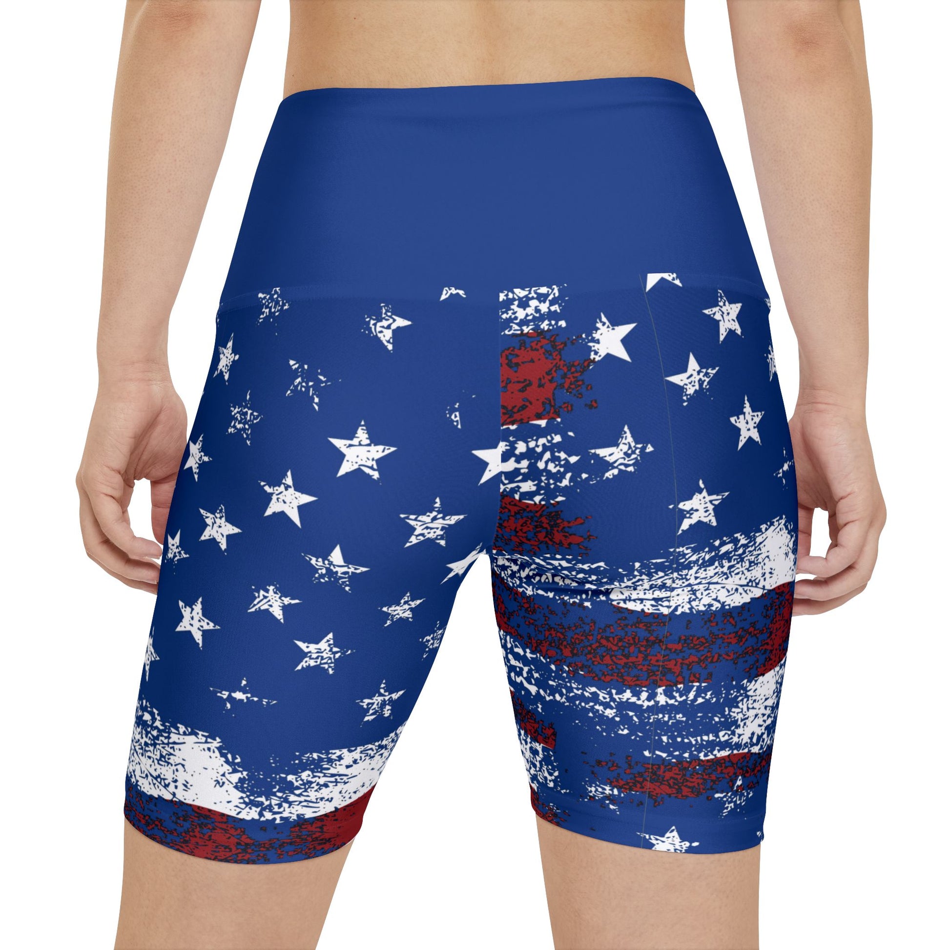 Female model wearing patriotic American flag bike shorts with distressed stars and stripes design, back view product mockup.