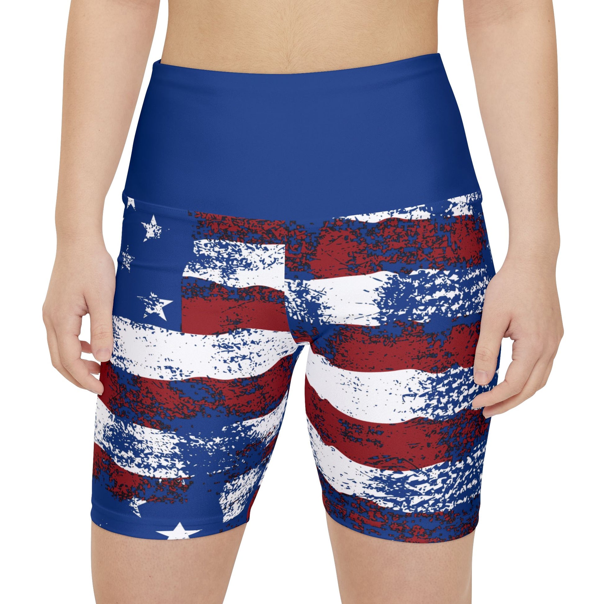 Female model wearing patriotic American flag bike shorts with distressed stars and stripes design, front view product mockup.