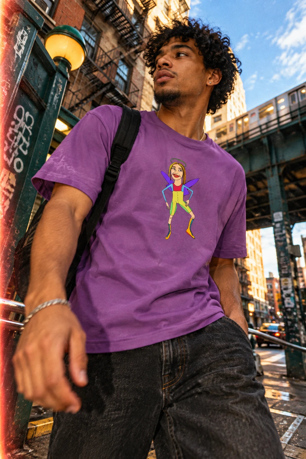 Angelic Sportsy graphic T-shirt in purple with colorful original angel character artwork, editorial flat lay
