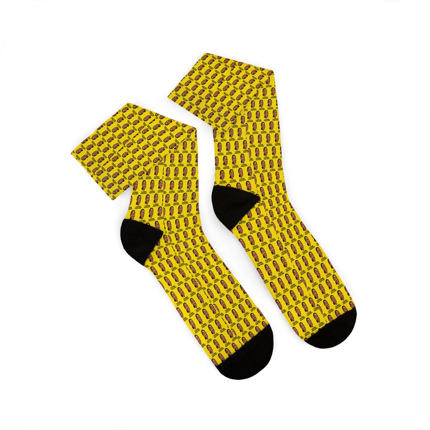 Folded pair of yellow AOC crew socks displaying the repeating Alexandria Ocasio-Cortez artwork pattern and black heel and toe accents.