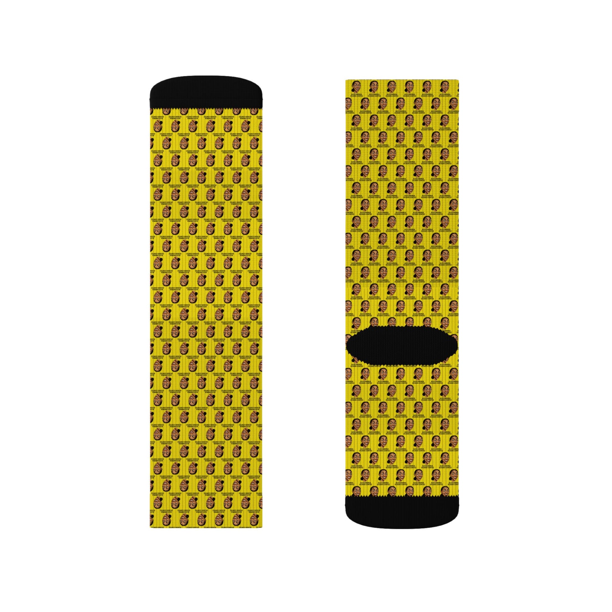 Front and back product view of yellow AOC crew socks featuring a repeating Alexandria Ocasio-Cortez face pattern with black heel and toe accents.