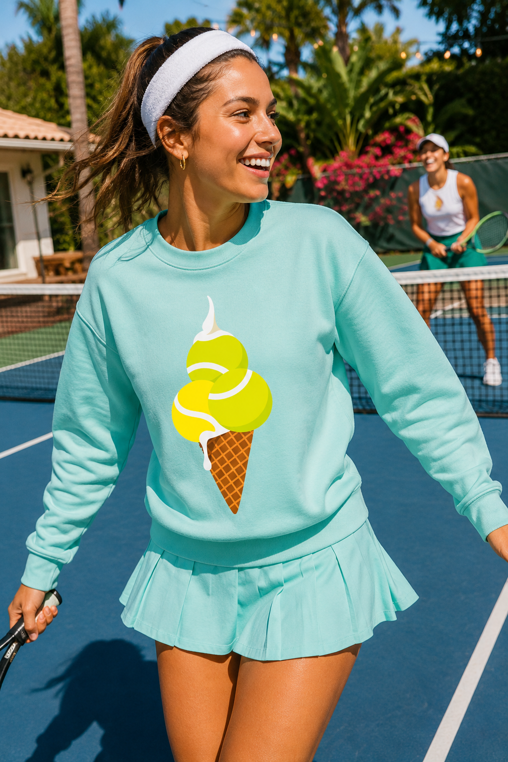 Woman wearing aqua tennis sweatshirt and matching skirt while playing tennis