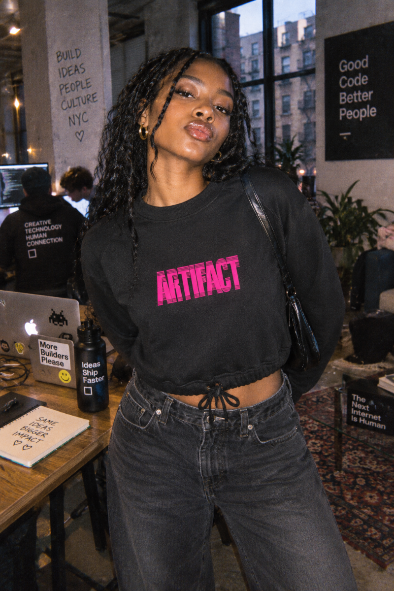 Gen Z woman wearing black Artifact Women’s Boxy Fleece Crewneck sweatshirt in NYC tech workspace