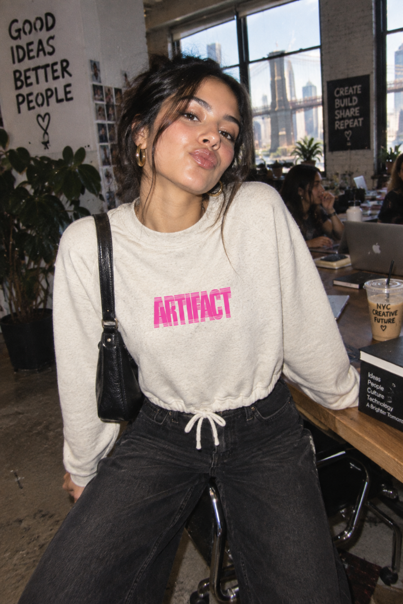 Young woman wearing oatmeal Artifact Women’s Boxy Fleece Crewneck sweatshirt in NYC creative workspace