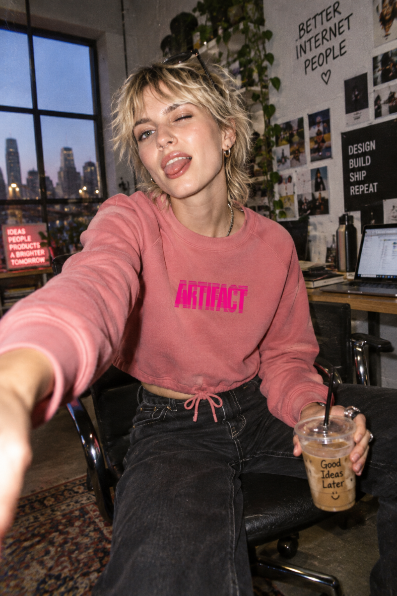 Young woman wearing rose Artifact Women’s Boxy Fleece Crewneck sweatshirt in modern tech studio