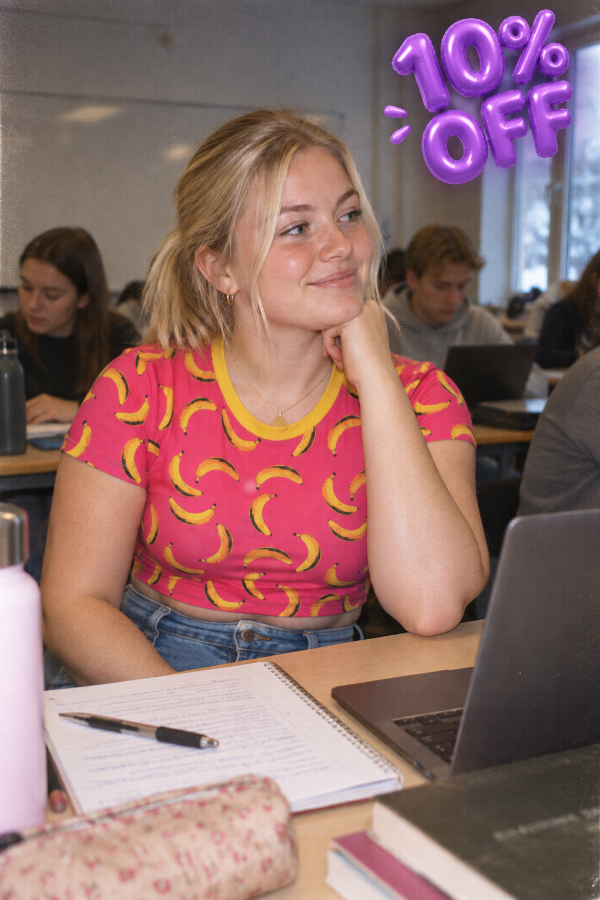 A blonde girl wearing a Banana Print Crop Top in a college classroom