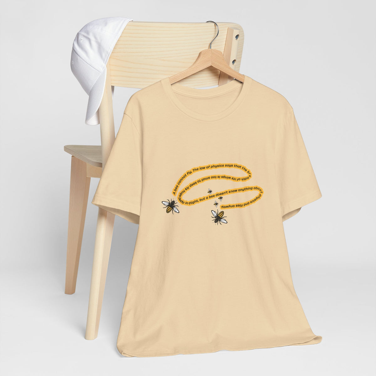 Soft cream bee quote graphic T-shirt displayed on wooden hanger