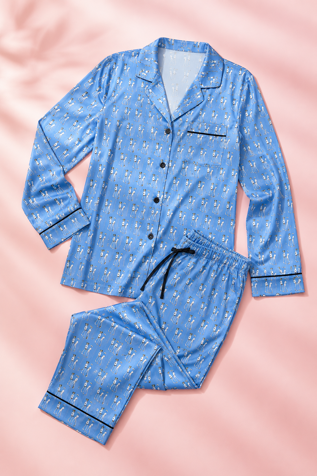Bikini Nenas women's satin pajama set flat lay on a soft pink background featuring original hand-drawn artwork and matching sleepwear pieces.