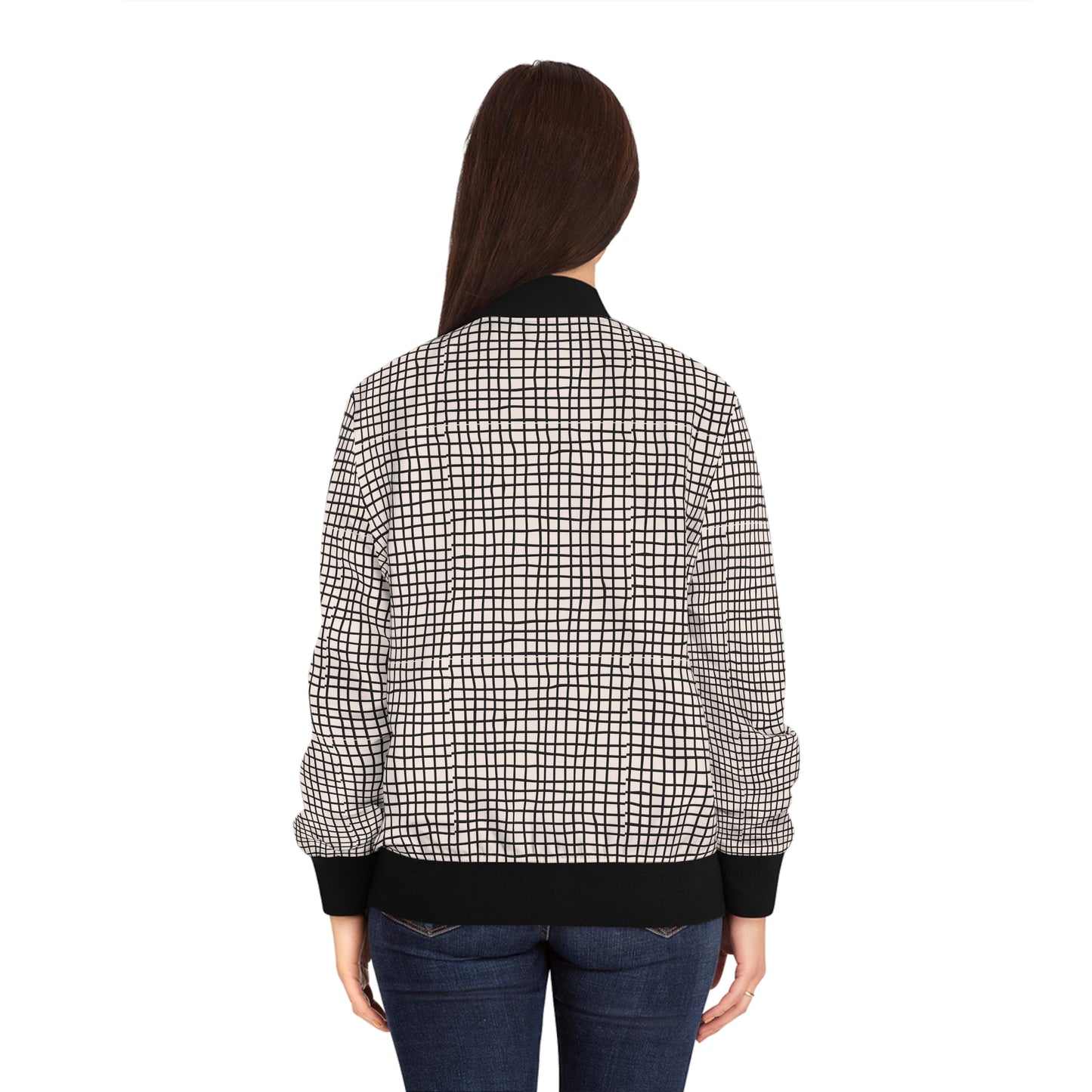 Back view of woman wearing a black and white geometric grid bomber jacket.