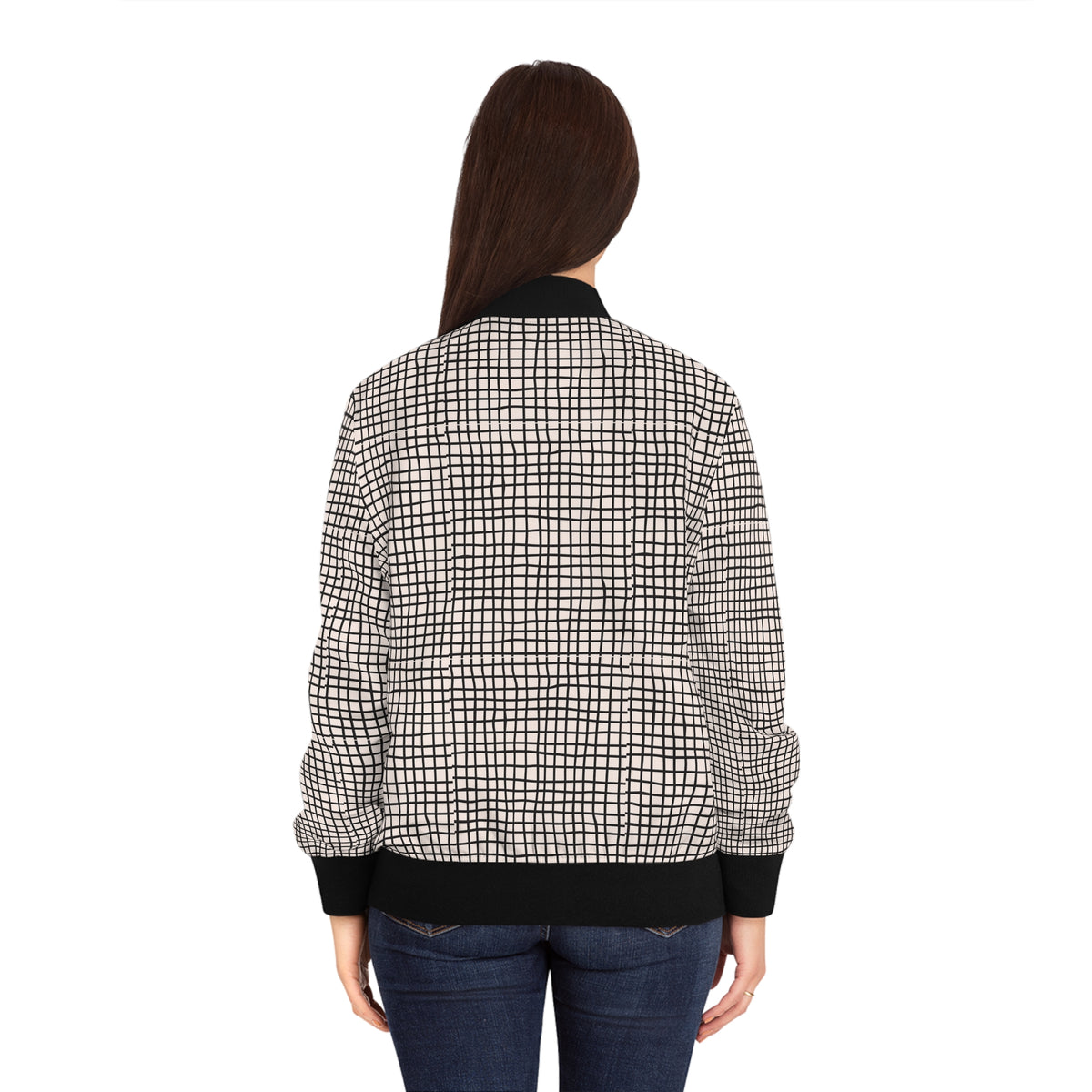 Back view of woman wearing a black and white geometric grid bomber jacket.
