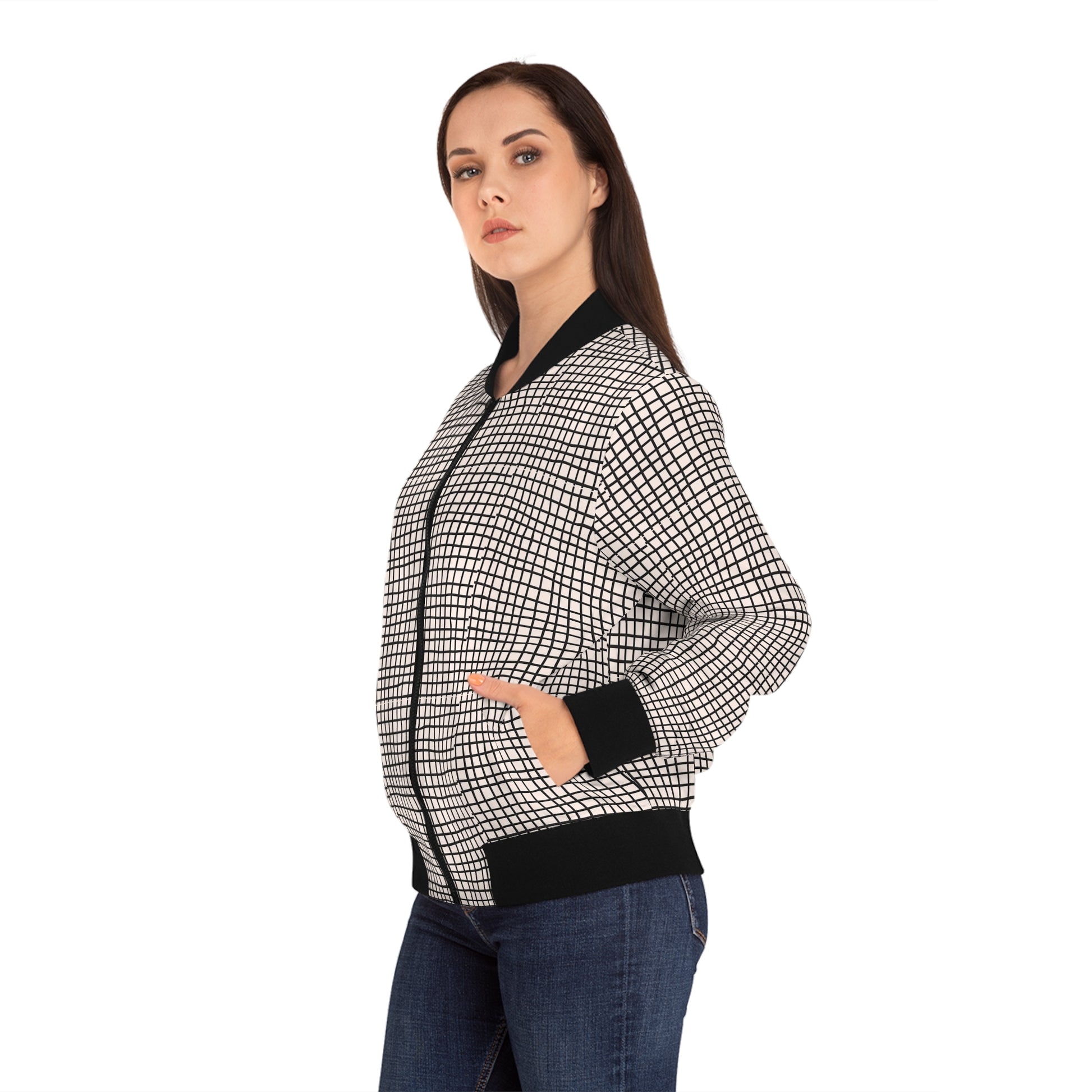 Three-quarter view of woman wearing a black and white geometric bomber jacket with hands in pockets.