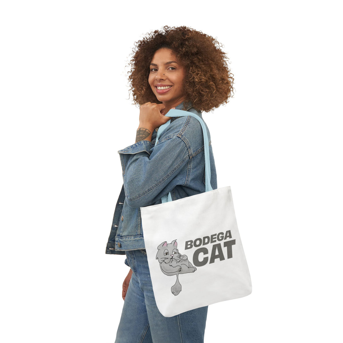 Bodega Cat white tote bag carried by woman in casual everyday outfit