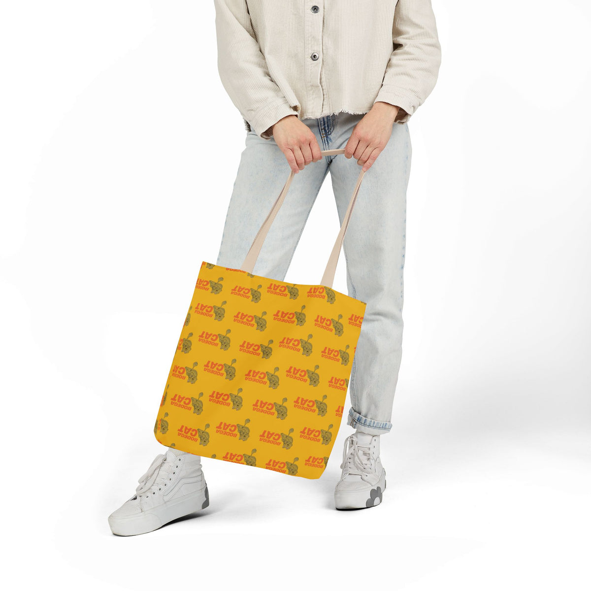 Bodega Cat yellow 16 x 16 tote bag shown from the front while being carried