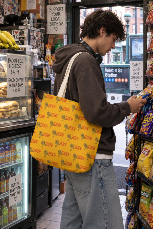Bodega Cat yellow tote bag carried inside a New York City bodega
