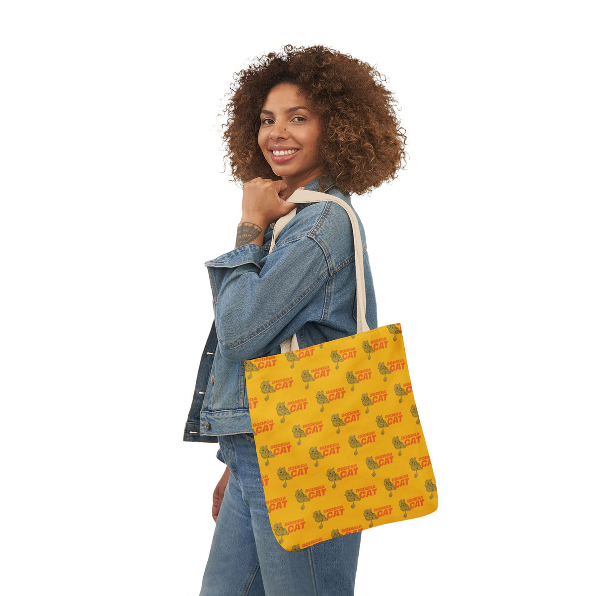 Bodega Cat yellow tote bag carried by woman in casual denim outfit