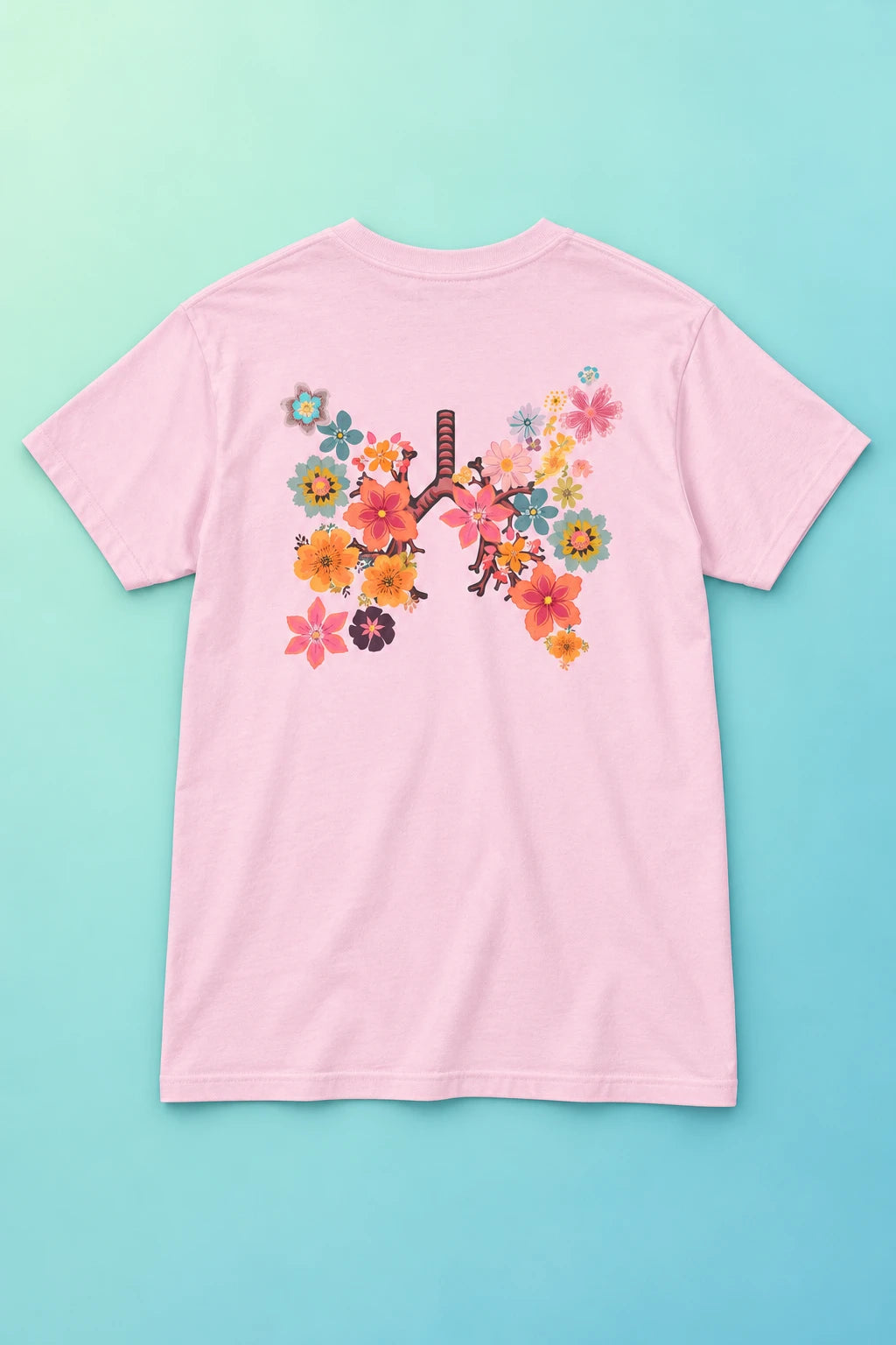 Pink Breath T-shirt laid back-side up on a mint gradient with the floral lungs artwork clearly visible.
