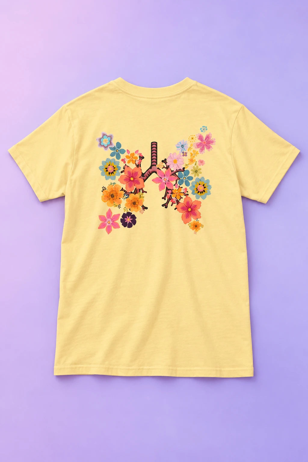 Yellow Breath T-shirt laid back-side up on a lilac gradient, displaying the floral lungs artwork.