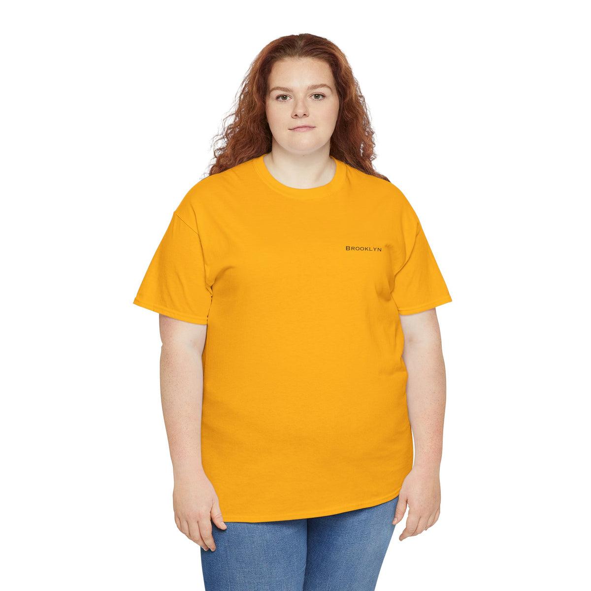 Woman wearing a golden yellow Brooklyn unisex T-shirt with dark jeans.