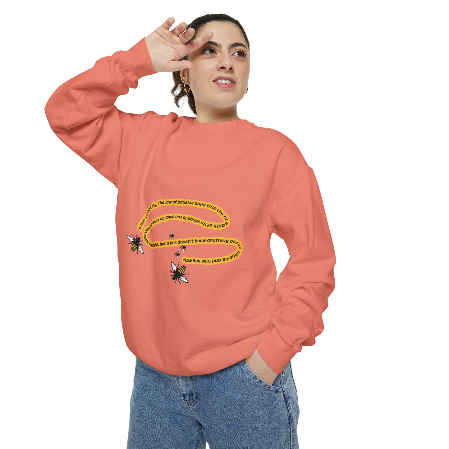 Woman modeling a peach bumblebee graphic crewneck sweatshirt with blue jeans.