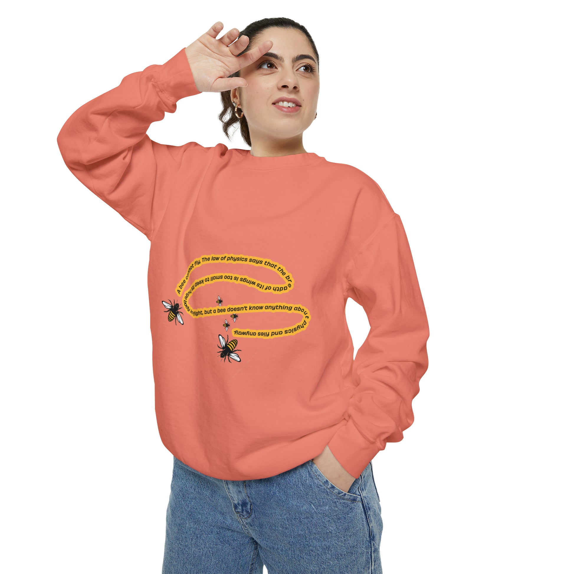 Woman modeling a peach bumblebee graphic crewneck sweatshirt with blue jeans.