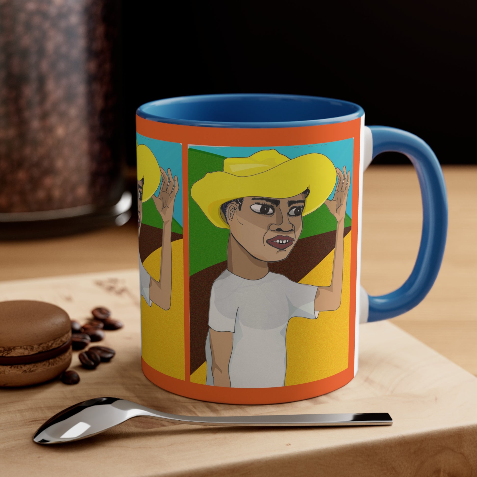 Cafetero Coffee Mug with blue handle and colorful artwork displayed beside coffee and breakfast accessories.