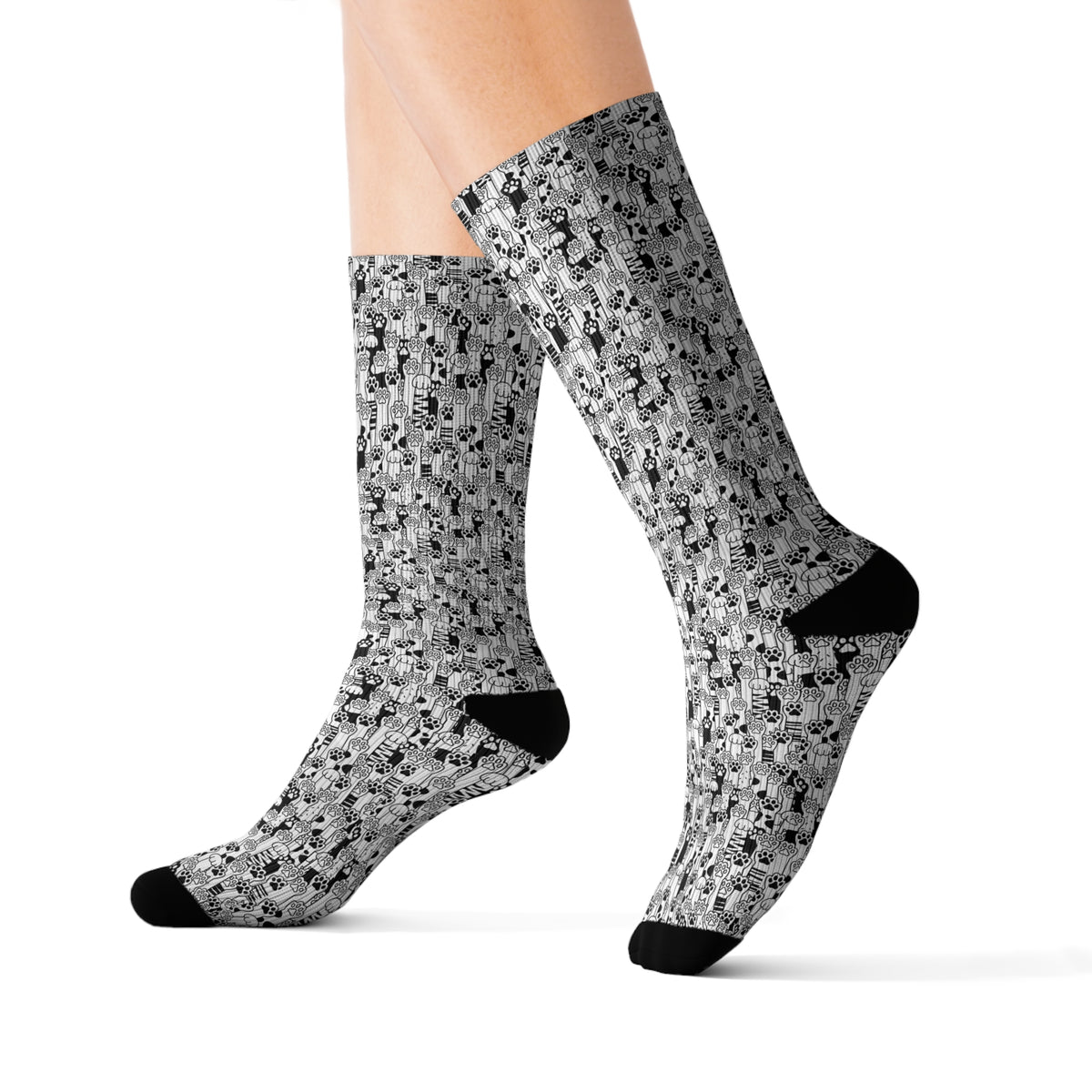 Side view of cat paw print crew socks showing the all-over black and white pattern.
