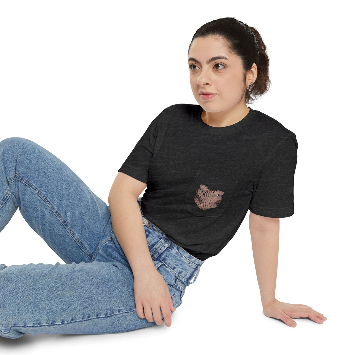 Woman wearing the Charlie Deluxe abstract face pocket T-shirt in charcoal gray with jeans