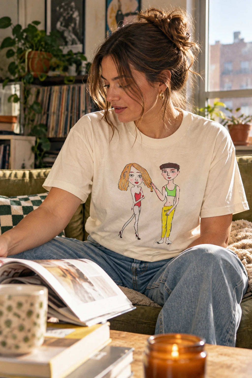 Woman wearing cream Charlotte & Van graphic T-shirt in a cozy apartment