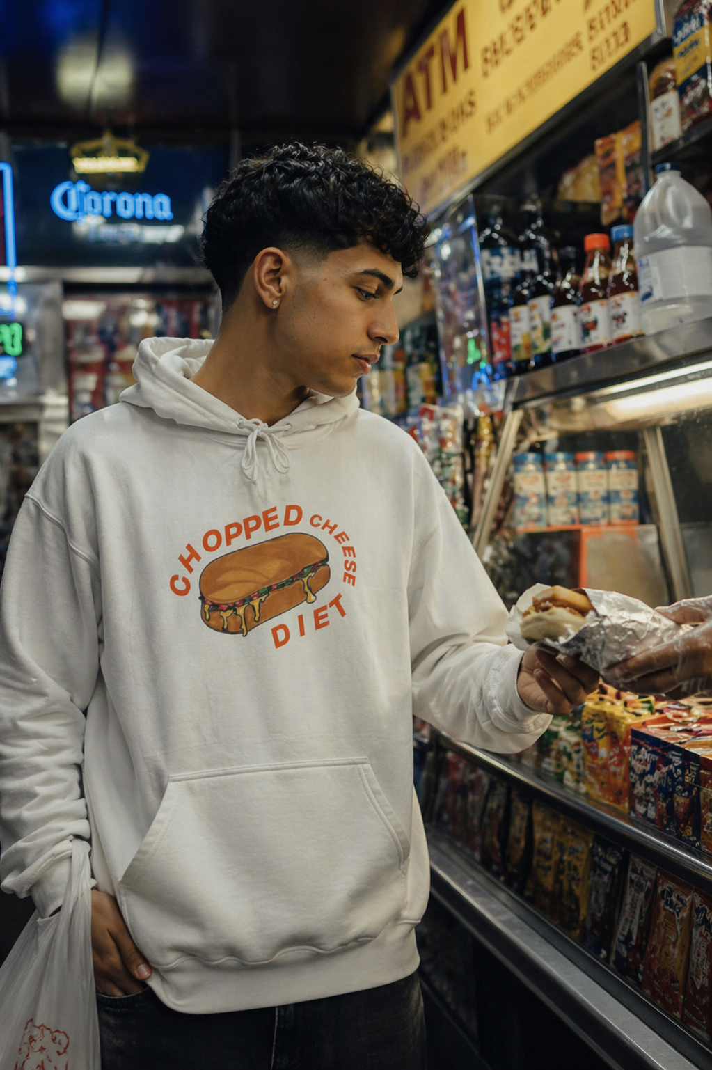 Man wearing a chopped cheese hoodie inside a NYC bodega, streetwear fashion inspired by New York sandwich culture.