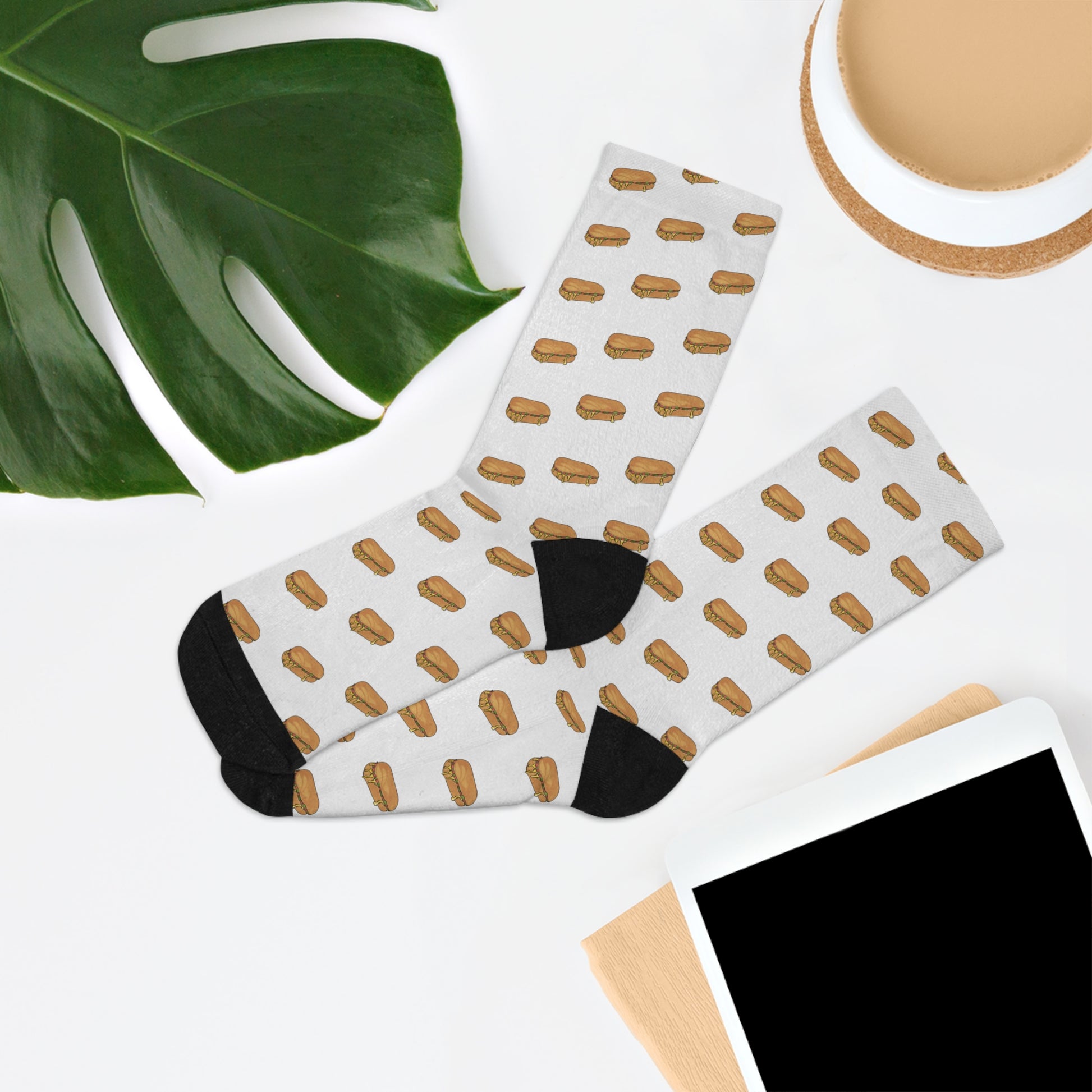 Chopped cheese unisex crew socks lifestyle flat lay with NYC deli sandwich pattern styled with plant and coffee on white background