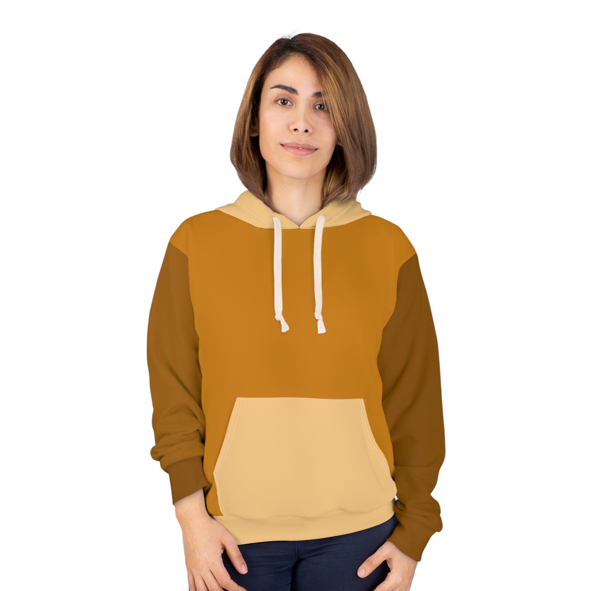 Female model wearing the Cinnamon Brown unisex hoodie featuring warm mustard, brown, and beige color-block panels with a front pocket and drawstring hood against a clean white background.