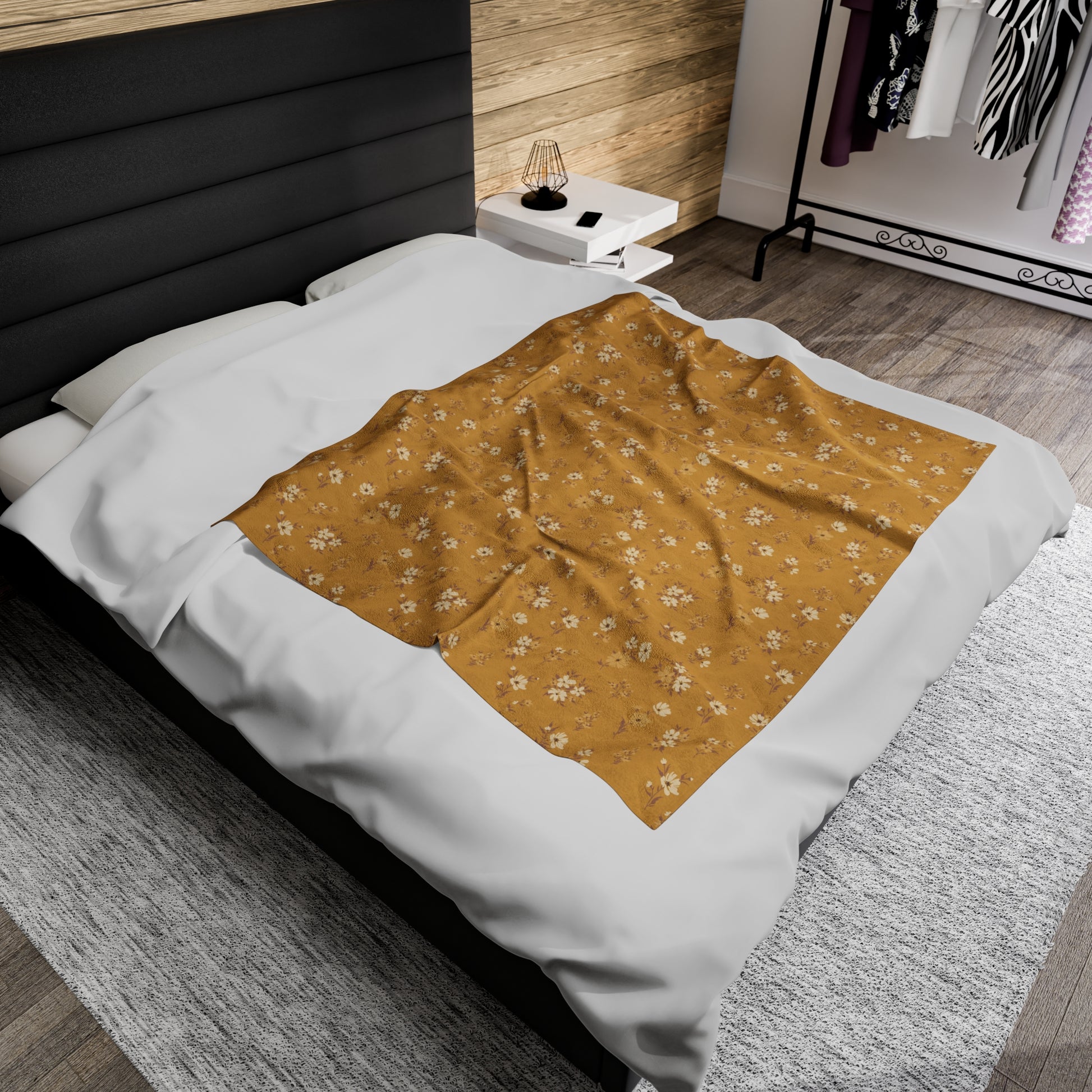 Cinnamon Flowers mustard floral throw blanket styled across a white bed in a modern bedroom