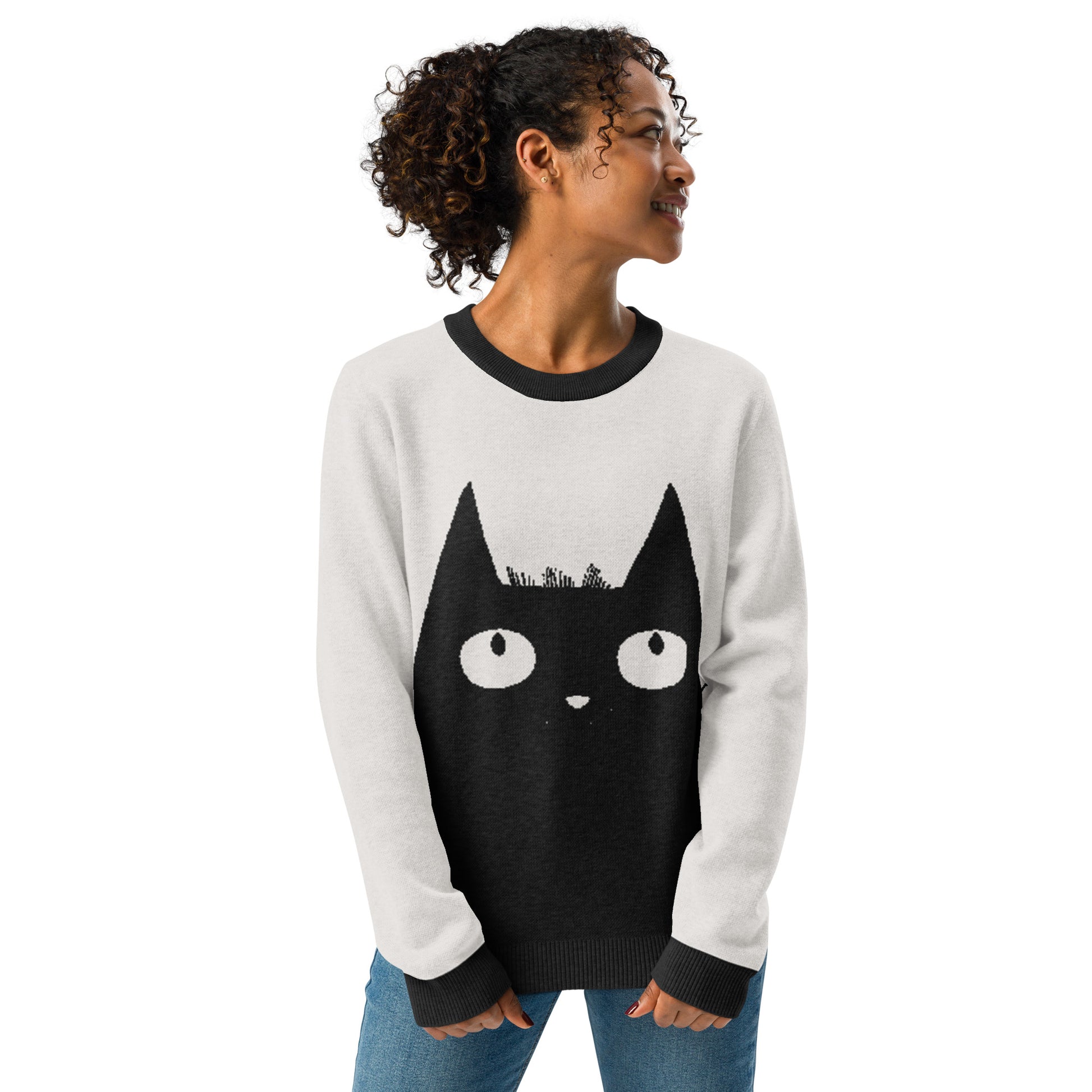 Studio image of a person wearing the cat graphic sweater facing forward with hands in pockets.
