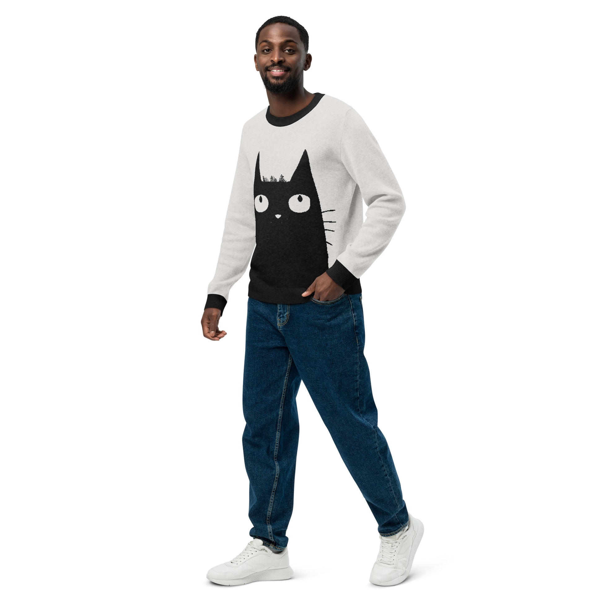 Full body studio image of a person wearing the cat graphic sweater with jeans.