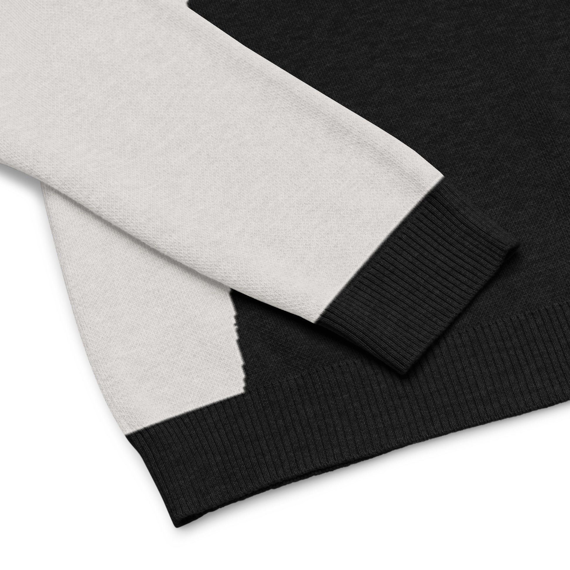 Close up of the sweater’s cuff, hem, and cat graphic showing knit detail.