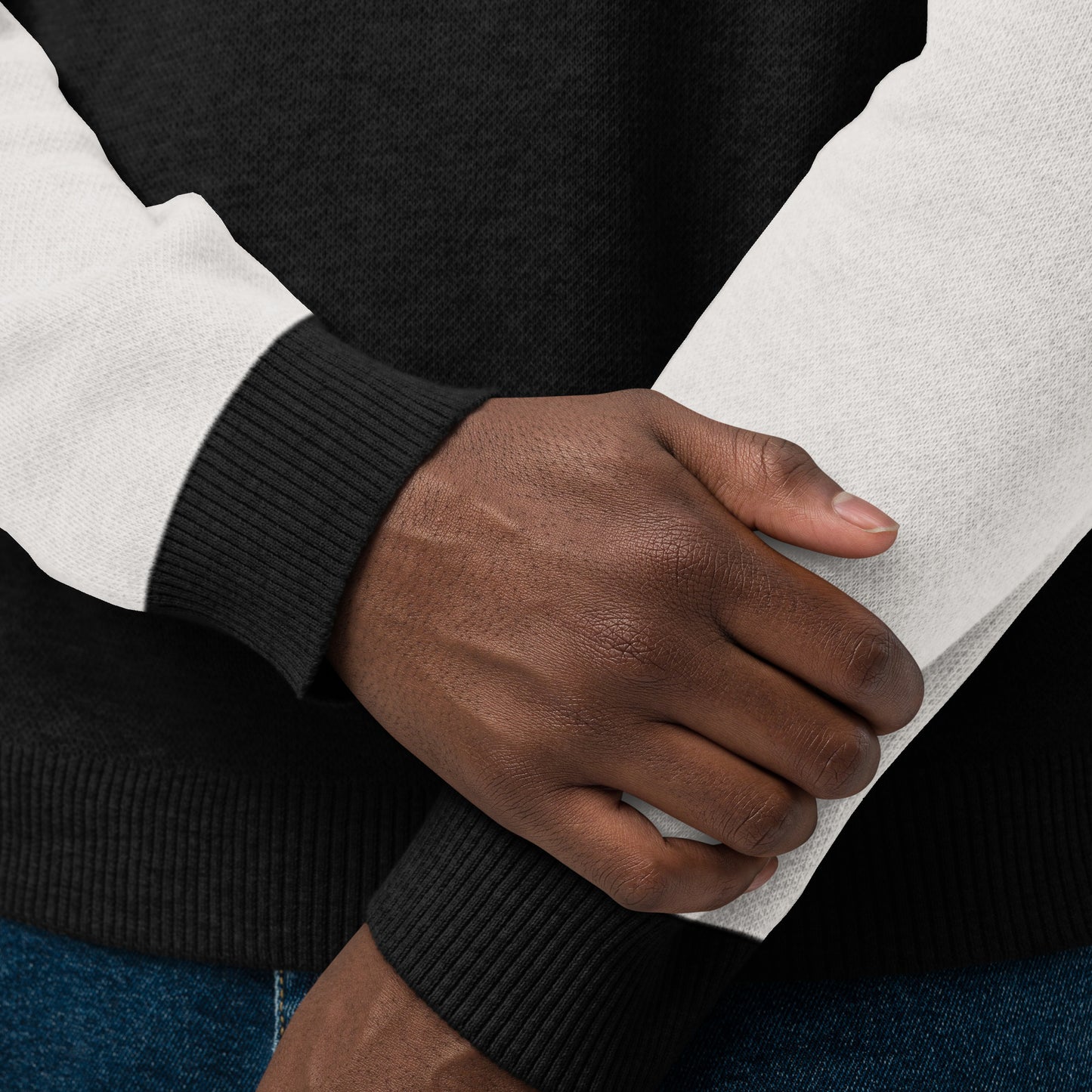 Close up of the sweater cuff and hem showing knit texture and contrasting black trim.