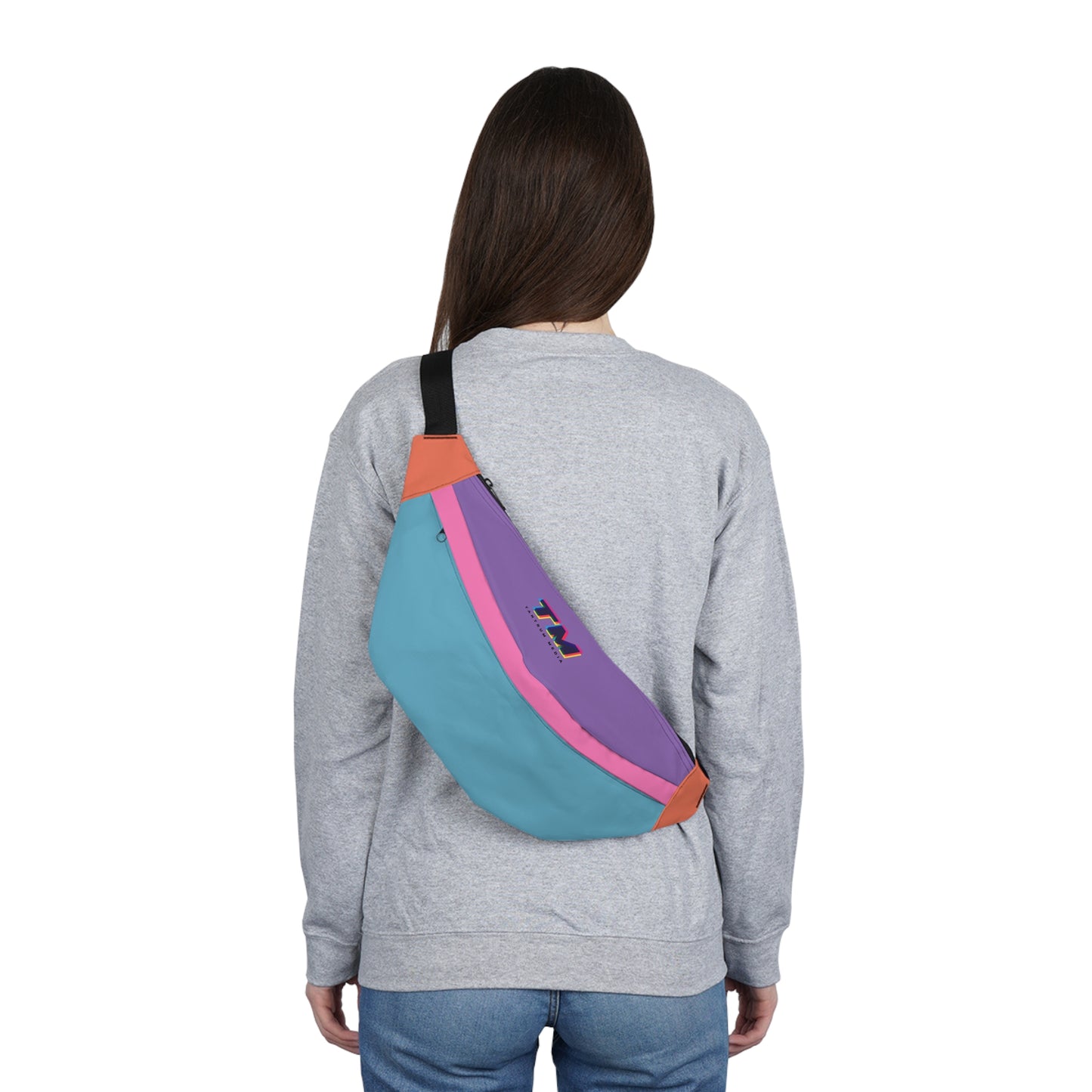 Woman wearing a colorful fanny pack crossbody from the back showing the adjustable black strap.