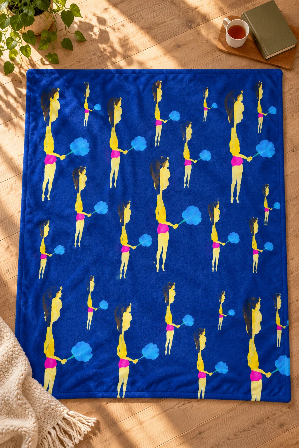 Tantrum Media Cotton Candy Art Fleece Throw Blanket – Blue 50 x 60 laid flat on a sunlit wood floor, showing the colorful illustrated print.