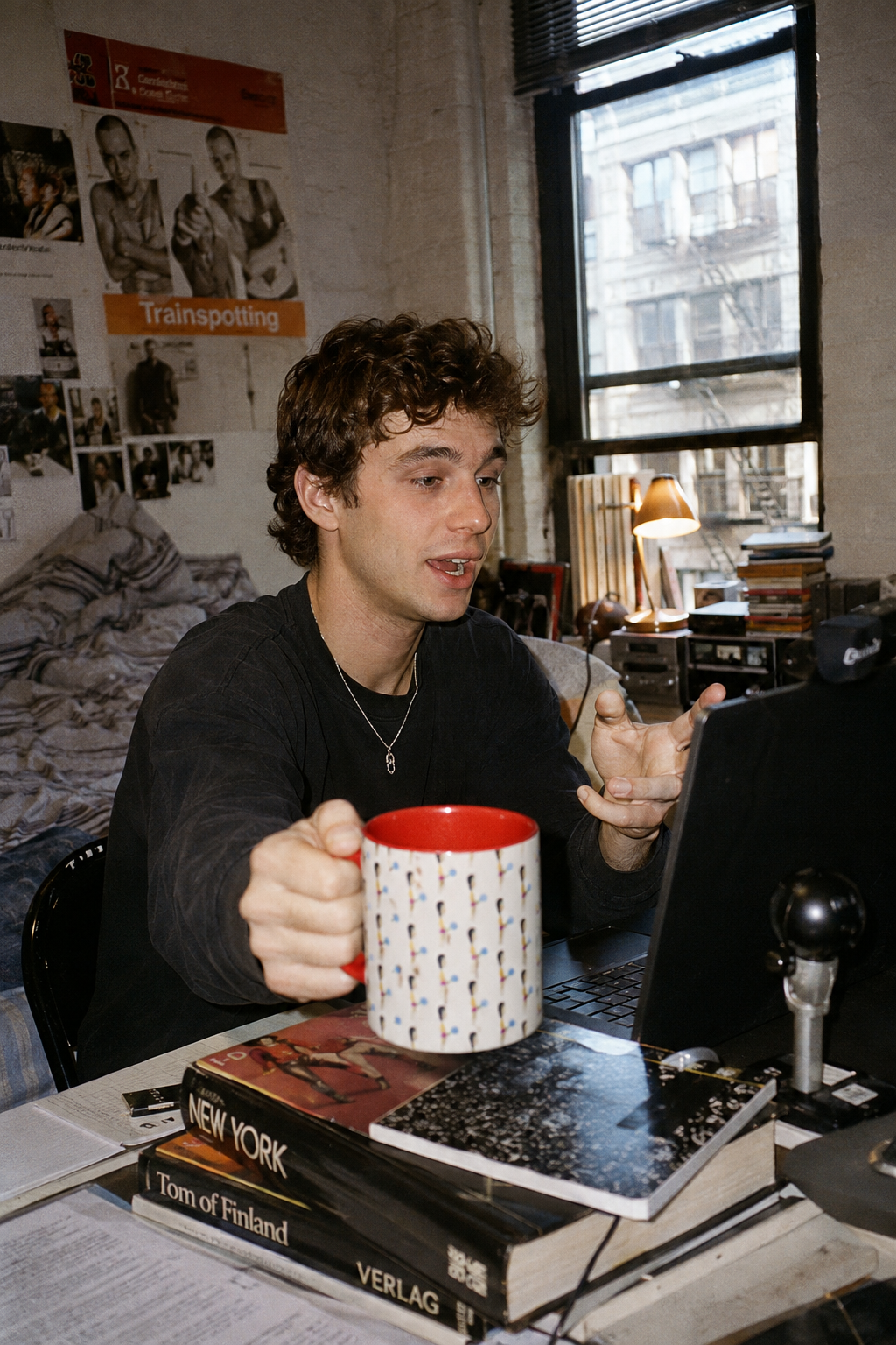 oung man holding the Cotton Candy Illustrated Mug during a video call in a small Manhattan studio apartment.