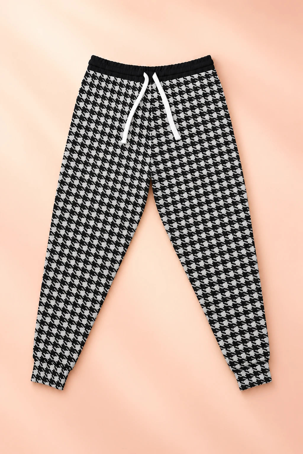 Front flat lay of black and white Dishwasher Joggers on a soft peach background