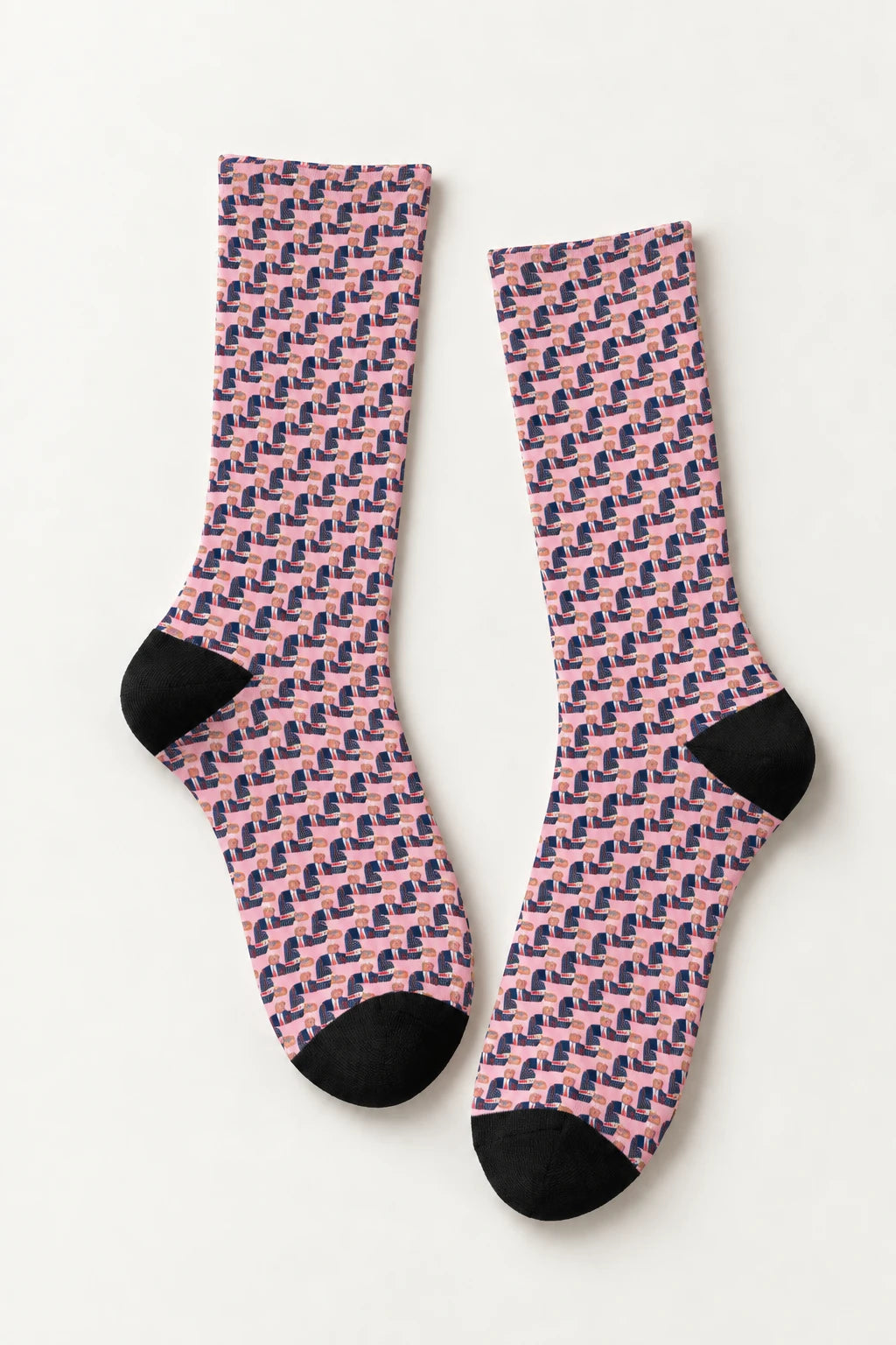Flat lay of Donald Trump pink crew socks with repeating portrait pattern and black heel and toe