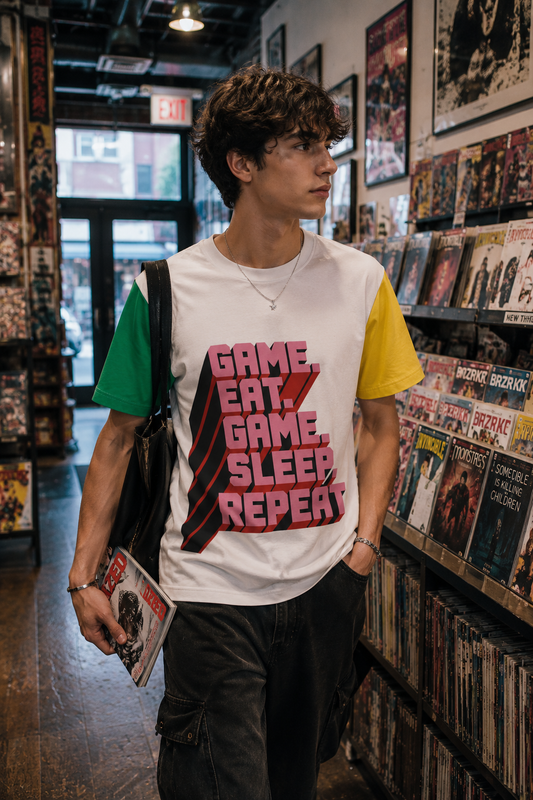 Male model wearing Eat Sleep Game Repeat unisex gamer t-shirt in retro gaming store