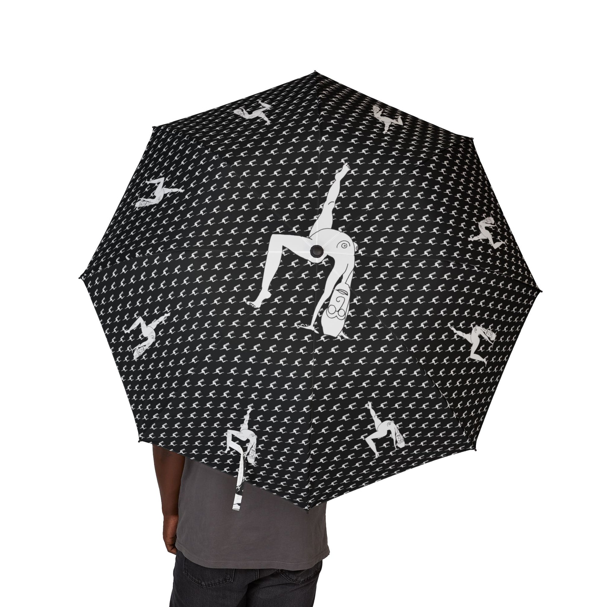 Person holding a black Elastika Umbrella with white hand-drawn dancing figures